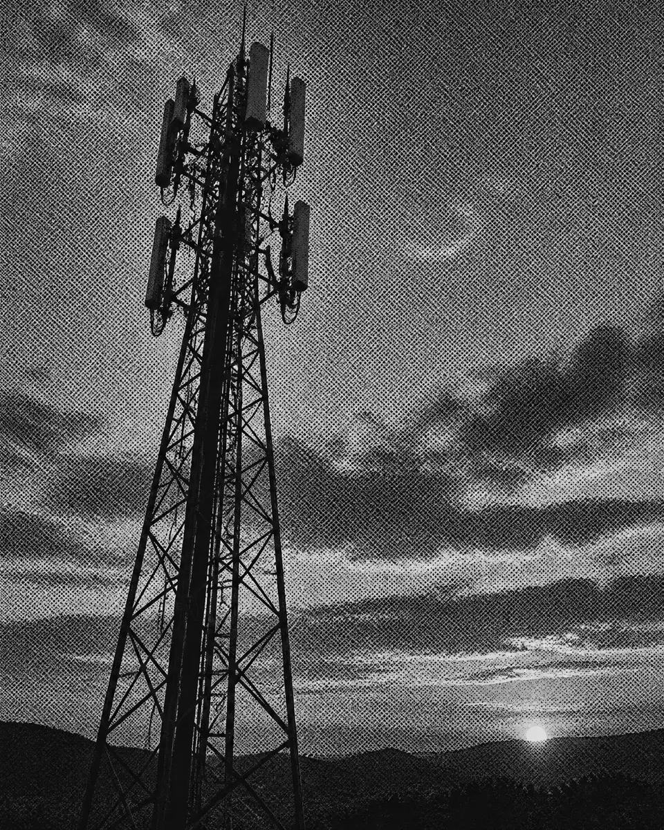 A cellular tower against a dusk sky